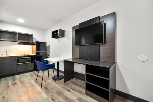 a kitchen with a desk with a blue chair at Southern Suites Douglasville in Douglasville