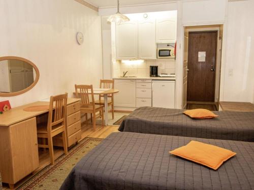 ein Zimmer mit zwei Betten und einem Tisch und einer Küche in der Unterkunft Holiday Home Kylpylä-hotelli- room 145 by Interhome in Ikaalinen