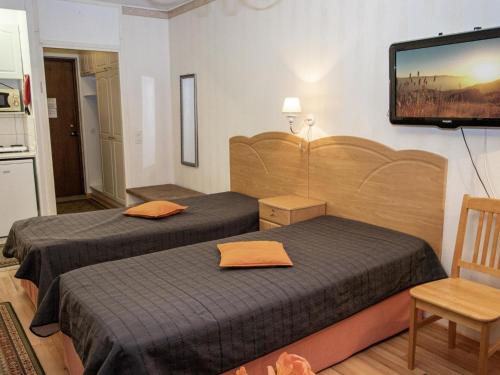 ein Hotelzimmer mit zwei Betten und einem Flachbildfernseher in der Unterkunft Holiday Home Kylpylä-hotelli- room 145 by Interhome in Ikaalinen
