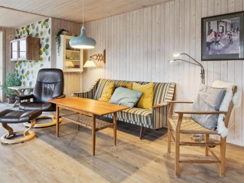 a living room with a couch and a table at Holiday Home Uddi - 1-3km from the sea by Interhome in Fanø