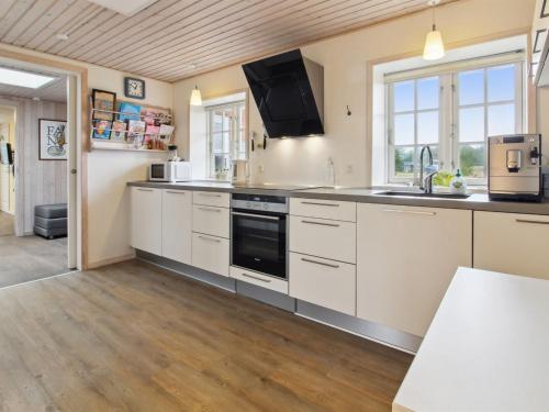 a kitchen with white cabinets and a sink at Holiday Home Uddi - 1-3km from the sea by Interhome in Fanø