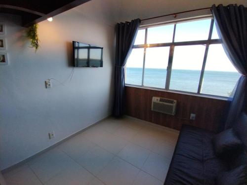 a room with a large window with a view of the ocean at Refúgio Laguna in Araruama