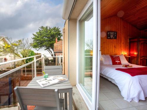 Cette chambre dispose d'un lit et d'un balcon avec une table. dans l'établissement Holiday Home Ker Zelia by Interhome, à La Bernerie-en-Retz