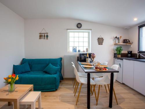 a living room with a blue couch and a table at Holiday Home La Prée by Interhome in La Plaine-sur-Mer