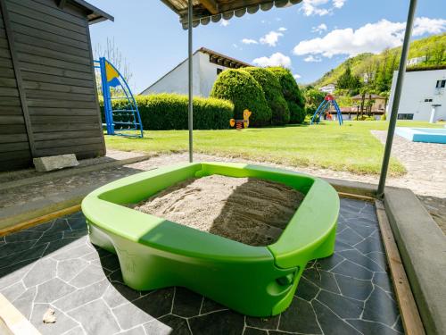 a green tub filled with dirt on a patio at Apartment Villaggio Sureggio C10A mit TicinoTicket by Interhome in Lugaggia