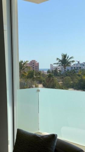 a room with a window with a view of the ocean at Apartamento 3 Recamaras en MAREA Los Cabos Playa Médano CSL in Cabo San Lucas