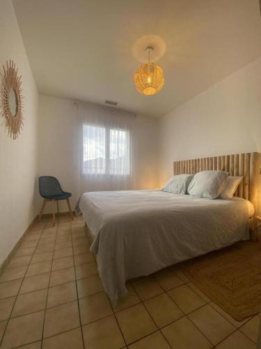 une chambre avec un grand lit et une chaise dans l'établissement Villa l'ESTIMADA, à Argelès-sur-Mer