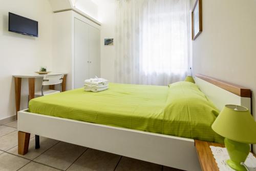 a bedroom with a green bed and a desk at B&B Belvedere in Agropoli