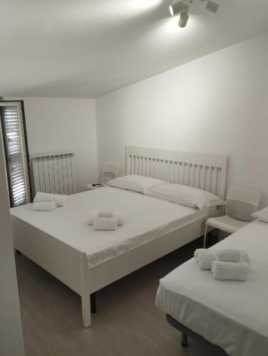 two beds in a room with white walls at Goccia di Mare in Roseto Capo Spulico