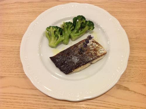 a white plate with a piece of fish and broccoli at Domus Australia in Rome