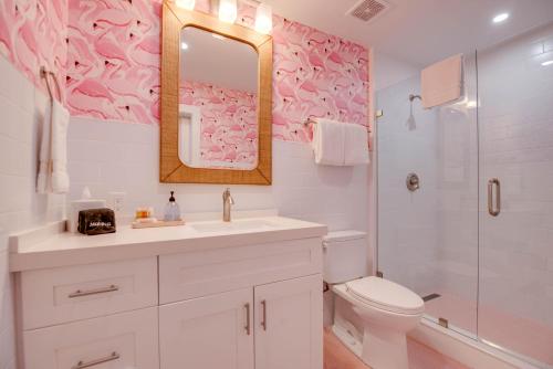 een badkamer met een wastafel, een toilet en een spiegel bij Feather Queen at Custom House Inn in Key West