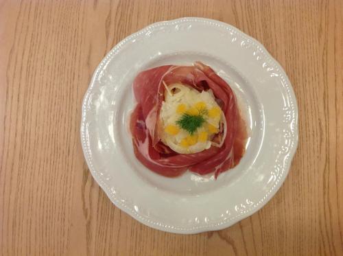 a white plate with food on a wooden table at Domus Australia in Rome
