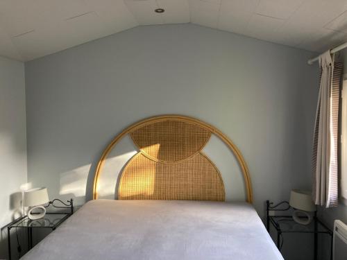 Bett in einem Zimmer mit zwei Nachttischen und zwei Fenstern in der Unterkunft Pitchounette villa Canaulaise 3ch 8p in Lacanau