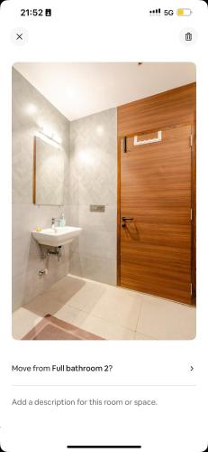 a bathroom with a sink and a wooden door at Reve Villa A, Dabolim Airport, Bogmalo Beach in Chicolna