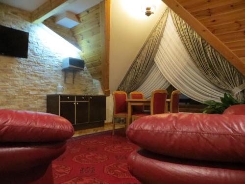 un soggiorno con tavolo e sedie in pelle rossa di Residenz Polenia a Zakopane