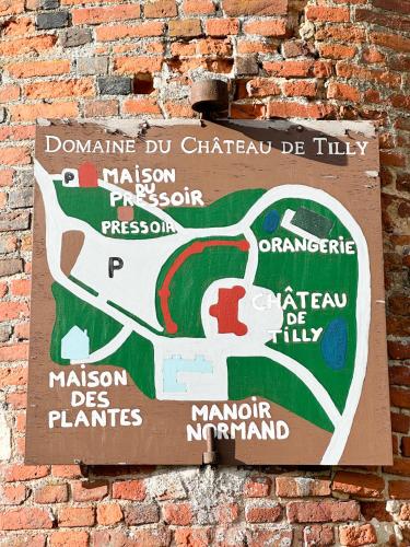 a sign on the side of a brick wall at Château de Tilly in Boissey-le-Châtel