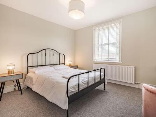 a bedroom with a bed and a desk and a window at Coastal Apartment with Sea View 2 Minutes from Beach and Town Center in Cromer