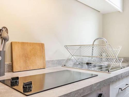 a kitchen counter with a sink and a basket on it at Coastal Apartment with Sea View 2 Minutes from Beach and Town Center in Cromer