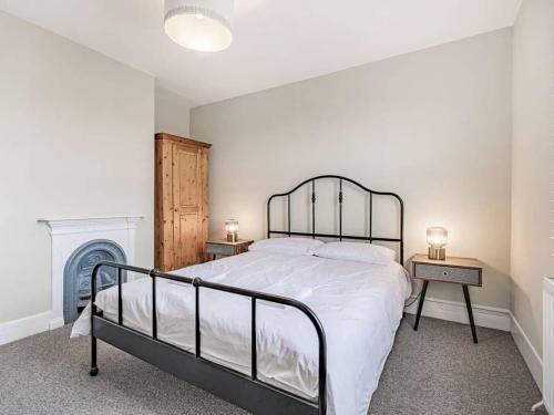 a bedroom with a large bed and a fireplace at Coastal Apartment with Sea View 2 Minutes from Beach and Town Center in Cromer