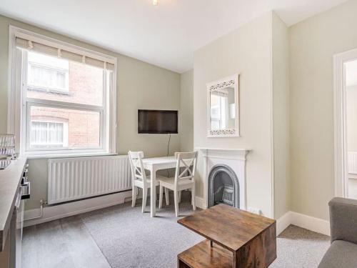 a living room with a table and a tv at Coastal Apartment with Sea View 2 Minutes from Beach and Town Center in Cromer