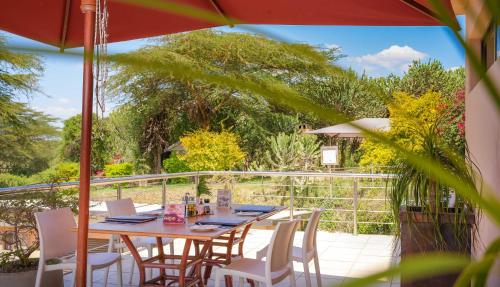 a table with chairs and an umbrella on a patio at Matteos Italian Restaurant,Bar & Accommodation in Naivasha