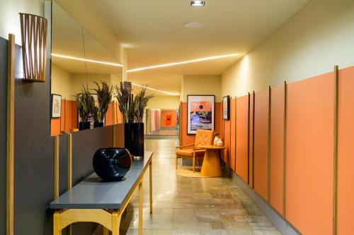 a hallway with orange cabinets and a vase on a table at Nordeste Palace Hotel - Fortaleza in Fortaleza