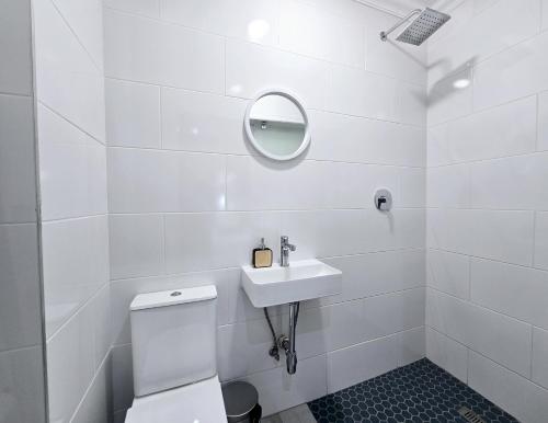 Un baño blanco con lavabo y espejo. en 52 The Bridge Apartment, en St Lucia