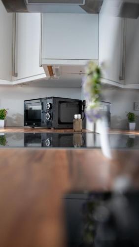 a kitchen with a microwave and a counter top at 3 bedroom home by the beach in Broad Haven