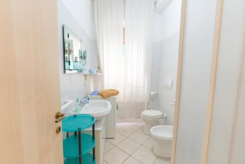 un bagno bianco con un water e un lavandino di Appartamenti Vacanze Roberta a San Vincenzo