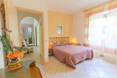 una camera da letto con un letto, un tavolo e uno specchio di Appartamenti Vacanze Roberta a San Vincenzo