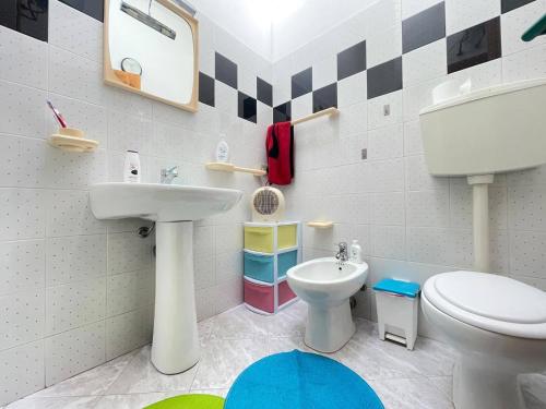 un bagno con un water bianco e un lavandino di Casa Vale a Villasimius