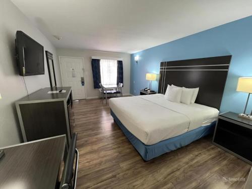 a hotel room with a bed and a television at Days Inn by Wyndham Orange in Orange