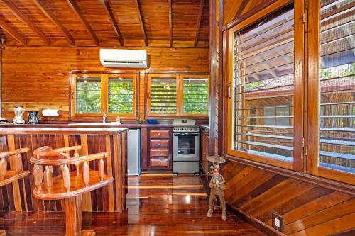 a kitchen with wooden walls and a stove top oven at Tambor Tropical Beach Resort- Adults Only in Tambor