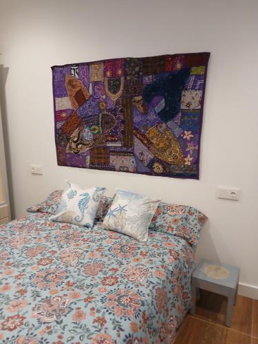 una cama con almohadas y una pintura en la pared en Residencial Golf jerez, en Jerez de la Frontera
