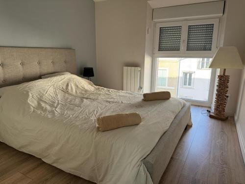 un grand lit blanc dans une chambre avec une fenêtre dans l'établissement Cozy apartment!, à Brives-Charensac