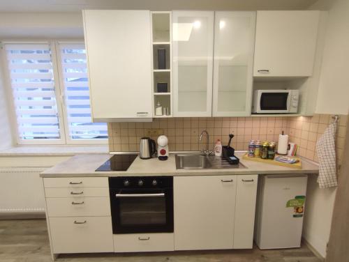 a kitchen with white cabinets and a stove top oven at Apartments Štěpánská Brno-centre in Brno