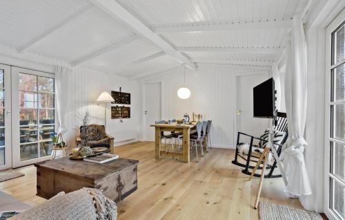 ÅlbækにあるCozy Home In Ålbæk With Wifiの白い壁のリビングルーム(テーブル付)