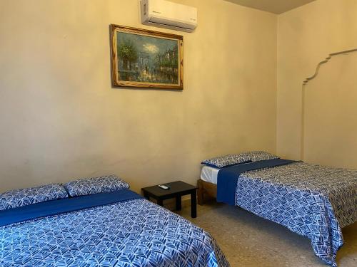 a room with two beds and a picture on the wall at My Family In Monterrey - Hostel in Monterrey