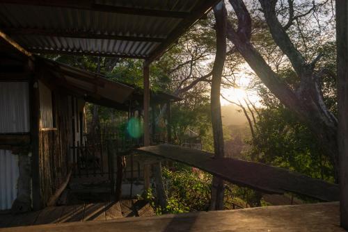 a porch of a house with the sun shining through the trees at Casa Medusa in El Gigante