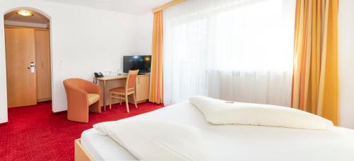 a bedroom with a bed and a desk with a computer at Sun Valley - Wildschönau in Auffach