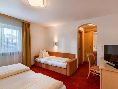 a hotel room with two beds and a flat screen tv at Sun Valley - Wildschönau in Auffach