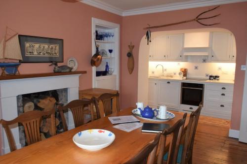 a kitchen and dining room with a wooden table and a dining room at Elm Cottage in Kippford