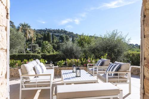 d'une terrasse avec des chaises longues blanches et une table. dans l'établissement Beautiful 4 bedroom villa with pool in Cannes center, à Cannes