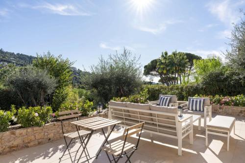 d'une terrasse avec une table, des chaises et un banc. dans l'établissement Beautiful 4 bedroom villa with pool in Cannes center, à Cannes