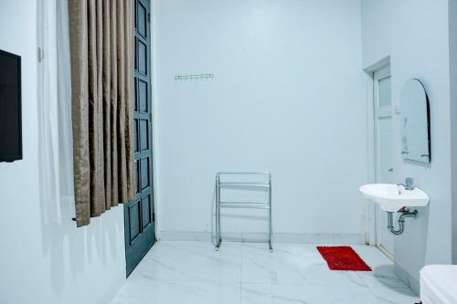 a white bathroom with a sink and a mirror at Hotel O Stasiun Cirebon Kejaksan Near Alun Alun Cirebon Formerly Family Homestay in Cirebon