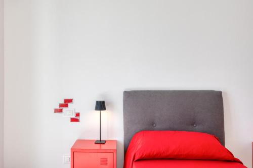 a bedroom with a red bed and a white wall at Appartamento Rubino in Tricase