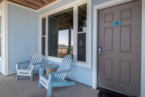 two chairs sitting on the front porch of a house at Host on the Coast in Folly Beach