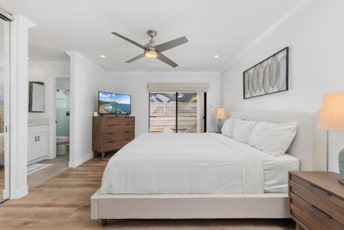 a white bedroom with a bed and a ceiling fan at Trackside Tranquility - TC522B in Solana Beach