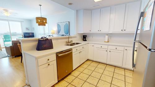 a kitchen with white cabinets and a sink at Seaside Villas 202 in Folly Beach