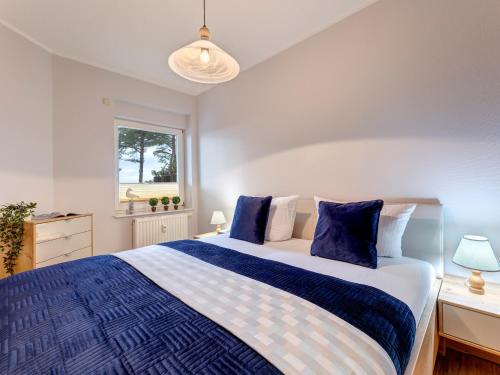 a bedroom with a large bed with blue and white sheets at Haus Berlin, Wohnung 2 in Loddin